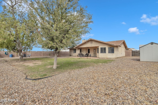 15210 S Country Club Way, Arizona City, AZ 85123 - rear view of property with a patio, a fenced backyard, stucco siding, an outdoor structure, and a storage shed