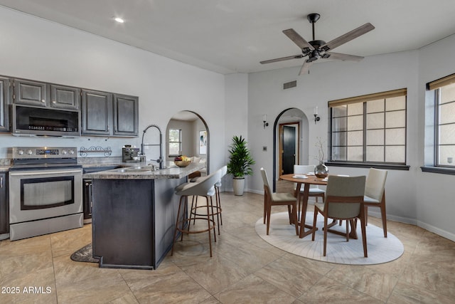 15210 S Country Club Way, Arizona City, AZ 85123 - kitchen featuring visible vents, a breakfast bar area, appliances with stainless steel finishes, arched walkways, and a sink