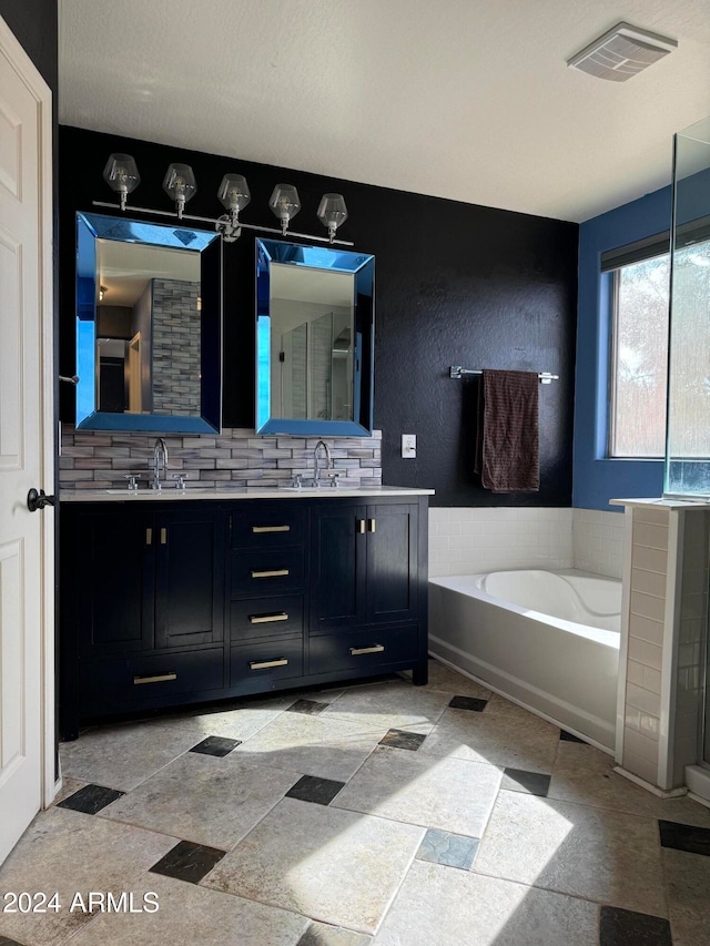 bathroom featuring tasteful backsplash, vanity, and a tub