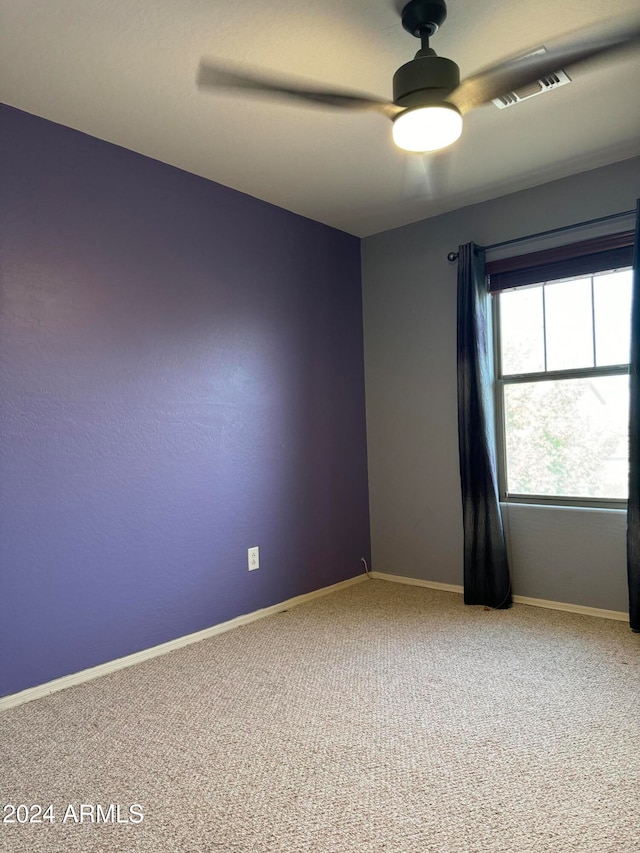 carpeted spare room with ceiling fan