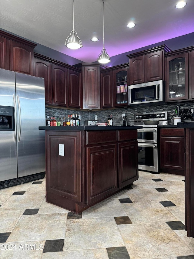 kitchen featuring appliances with stainless steel finishes, decorative backsplash, dark brown cabinets, and hanging light fixtures