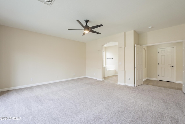 interior space with light carpet, ensuite bathroom, and ceiling fan