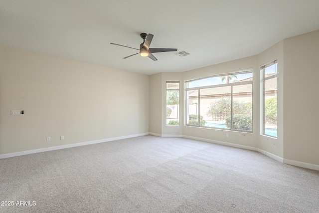 unfurnished room featuring light carpet, a wealth of natural light, and ceiling fan