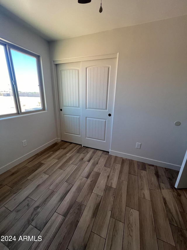 unfurnished bedroom featuring a closet and hardwood / wood-style floors