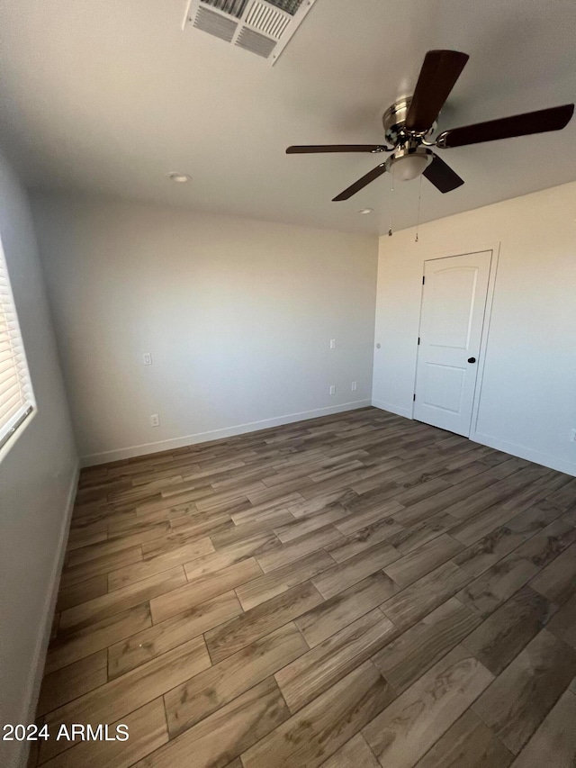 unfurnished bedroom featuring ceiling fan, a closet, and hardwood / wood-style floors