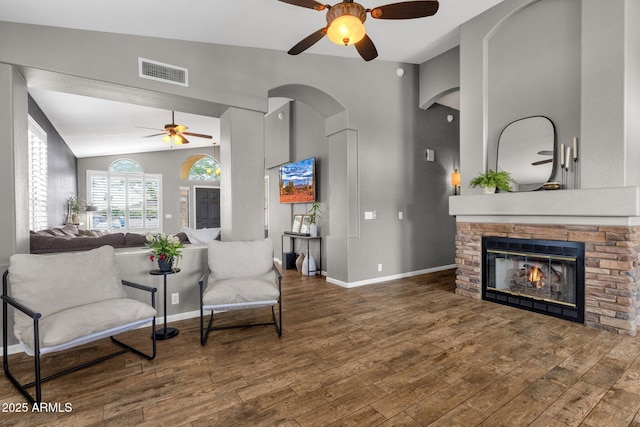 20239 N 39th Dr, Glendale, AZ 85308 - living area with ceiling fan, arched walkways, wood finished floors, a stone fireplace, and lofted ceiling