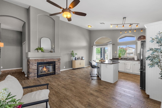 20239 N 39th Dr, Glendale, AZ 85308 - kitchen with a center island, dark countertops, white cabinets, freestanding refrigerator, and a kitchen bar