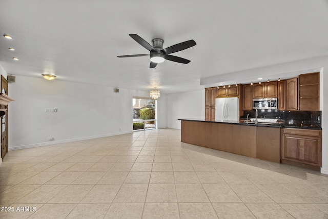 kitchen with range, light tile patterned floors, white refrigerator, ceiling fan with notable chandelier, and backsplash