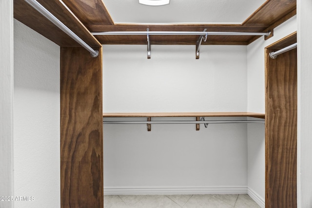 walk in closet with light tile patterned floors