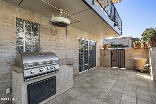 view of patio / terrace featuring ceiling fan, an outdoor kitchen, grilling area, and a balcony