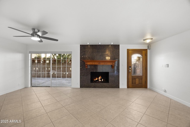 unfurnished living room featuring light tile patterned floors, a tile fireplace, and ceiling fan