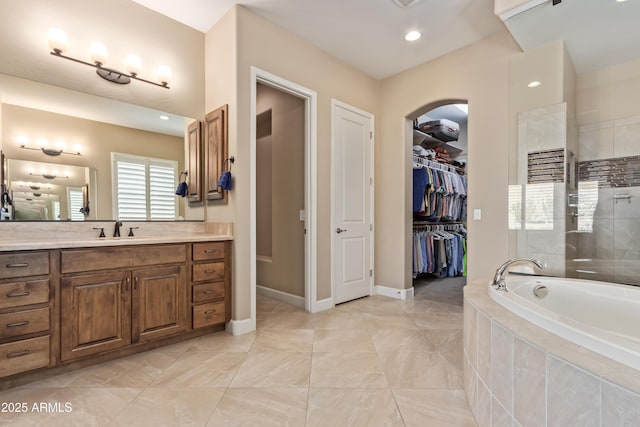 bathroom featuring a relaxing tiled tub and vanity