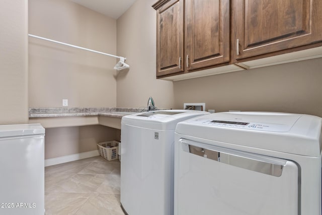 washroom with cabinets, washer and dryer, sink, and light tile patterned floors