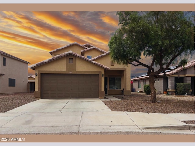 6538 W Nez Perce St, Phoenix, AZ 85043 - view of front facade with stucco siding, an attached garage, concrete driveway, and a tiled roof