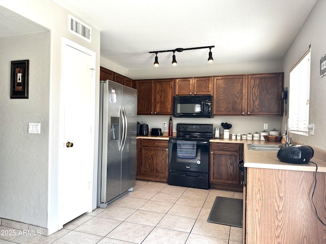 6538 W Nez Perce St, Phoenix, AZ 85043 - kitchen with black appliances, a sink, light tile patterned floors, light countertops, and rail lighting