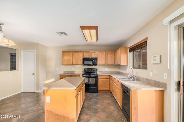 kitchen featuring pendant lighting, black appliances, dark tile patterned flooring, sink, and a kitchen island