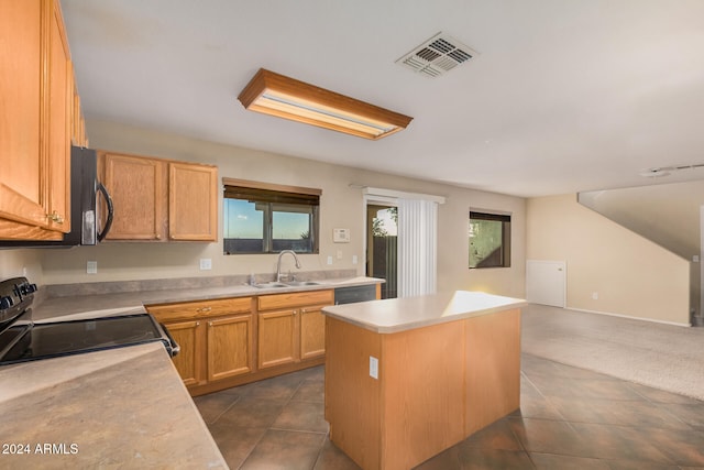 kitchen featuring a center island, dark tile patterned flooring, sink, light brown cabinetry, and stainless steel appliances