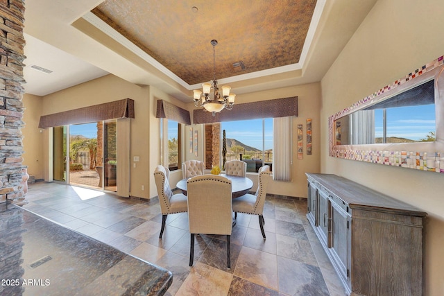 dining room with a raised ceiling and a chandelier