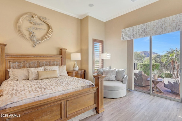 bedroom with access to exterior, a mountain view, light wood-type flooring, and crown molding