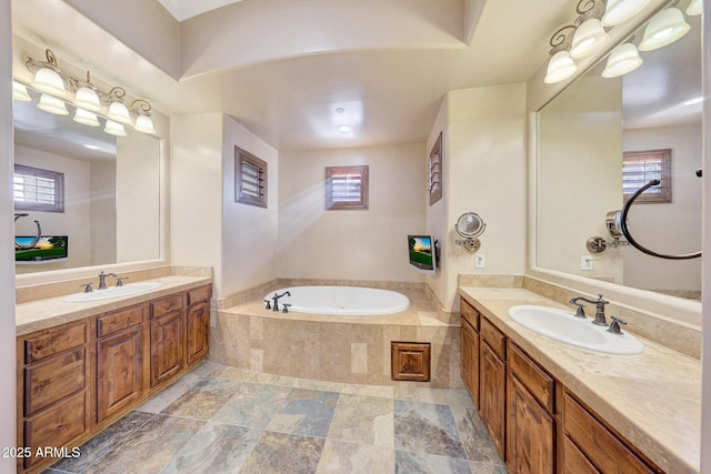 bathroom featuring vanity, tiled tub, and a wealth of natural light