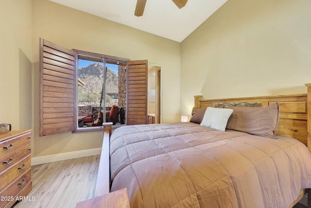 bedroom with ceiling fan, light hardwood / wood-style floors, and vaulted ceiling