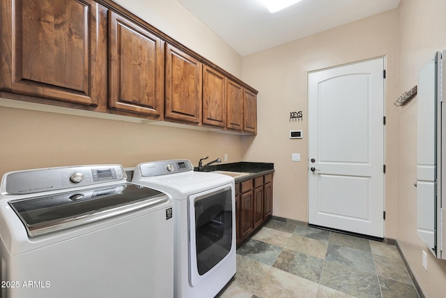 clothes washing area with cabinets, separate washer and dryer, and sink