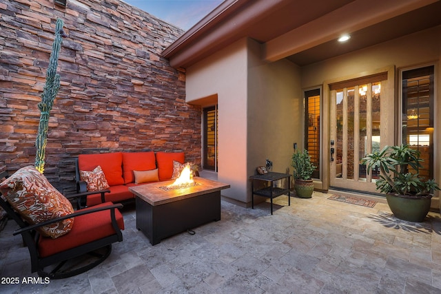 patio terrace at dusk featuring an outdoor living space with a fire pit