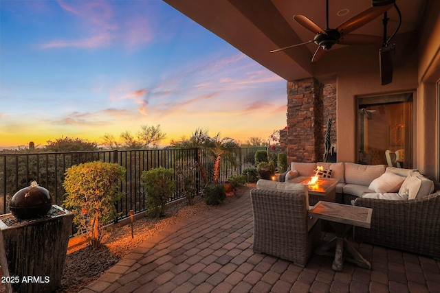 patio terrace at dusk with an outdoor living space and ceiling fan