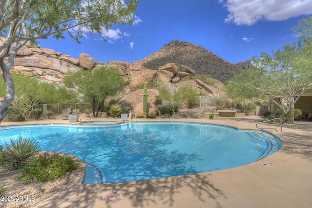 view of swimming pool featuring a mountain view, a patio, and an in ground hot tub