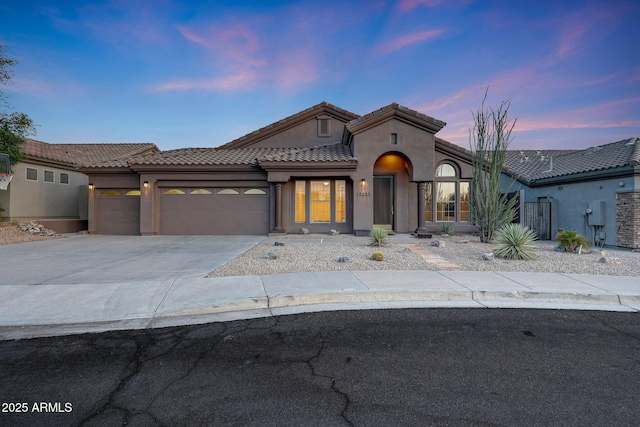 10253 E Indigo Dr, Scottsdale, AZ 85255 - mediterranean / spanish home with an attached garage, stucco siding, concrete driveway, and a tile roof