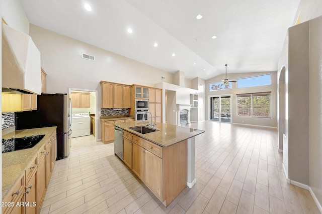 10253 E Indigo Dr, Scottsdale, AZ 85255 - kitchen with stainless steel appliances, a ceiling fan, washer / clothes dryer, a sink, and tasteful backsplash