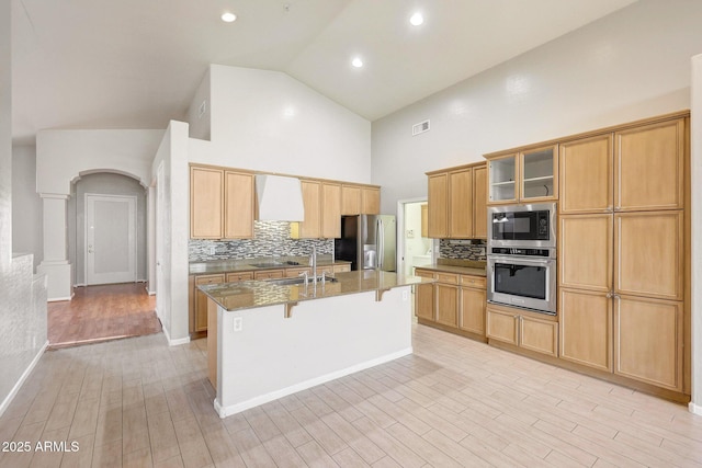 10253 E Indigo Dr, Scottsdale, AZ 85255 - kitchen featuring appliances with stainless steel finishes, high vaulted ceiling, a breakfast bar, decorative backsplash, and a sink