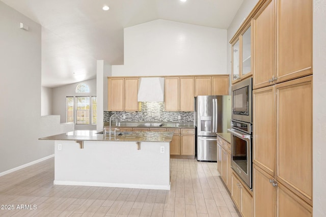 10253 E Indigo Dr, Scottsdale, AZ 85255 - kitchen with appliances with stainless steel finishes, vaulted ceiling, a sink, a breakfast bar area, and tasteful backsplash