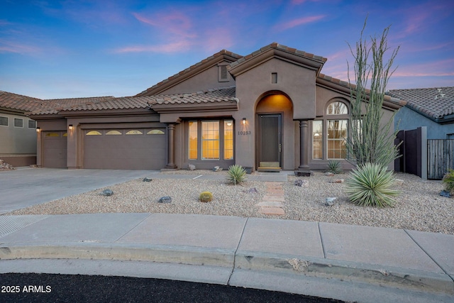 10253 E Indigo Dr, Scottsdale, AZ 85255 - mediterranean / spanish house with stucco siding, an attached garage, concrete driveway, and a tile roof