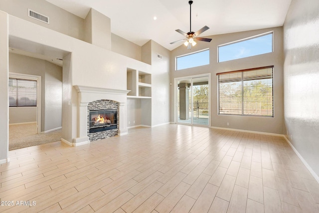 10253 E Indigo Dr, Scottsdale, AZ 85255 - unfurnished living room with healthy amount of natural light, ceiling fan, a tile fireplace, high vaulted ceiling, and baseboards