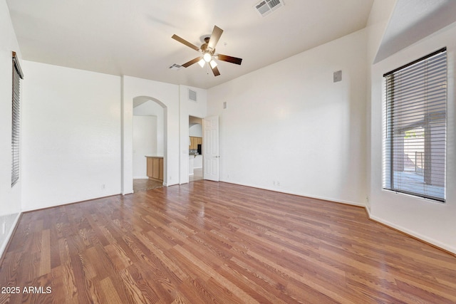 10253 E Indigo Dr, Scottsdale, AZ 85255 - spare room featuring arched walkways, ceiling fan, wood finished floors, and baseboards