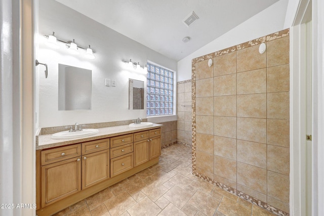 10253 E Indigo Dr, Scottsdale, AZ 85255 - full bathroom featuring double vanity, lofted ceiling, a tile shower, and stone finish floors