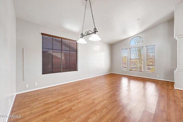 10253 E Indigo Dr, Scottsdale, AZ 85255 - spare room featuring lofted ceiling, light wood-type flooring, baseboards, and a chandelier
