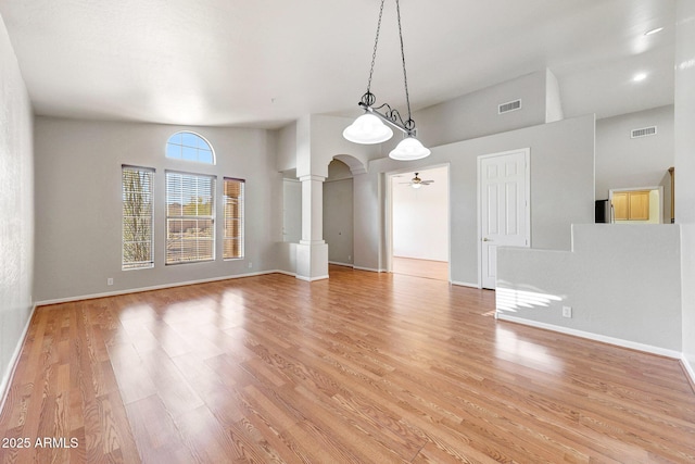 10253 E Indigo Dr, Scottsdale, AZ 85255 - empty room featuring ceiling fan, light wood-type flooring, decorative columns, arched walkways, and baseboards