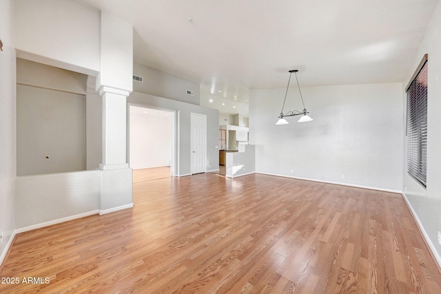 10253 E Indigo Dr, Scottsdale, AZ 85255 - unfurnished living room with ornate columns, light wood-style floors, and baseboards
