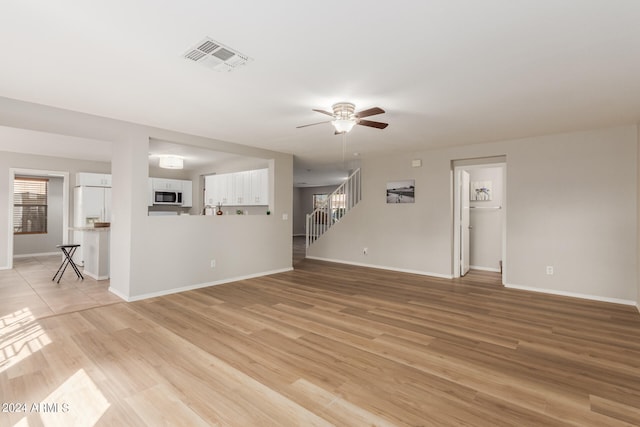 unfurnished living room featuring light hardwood / wood-style floors and ceiling fan