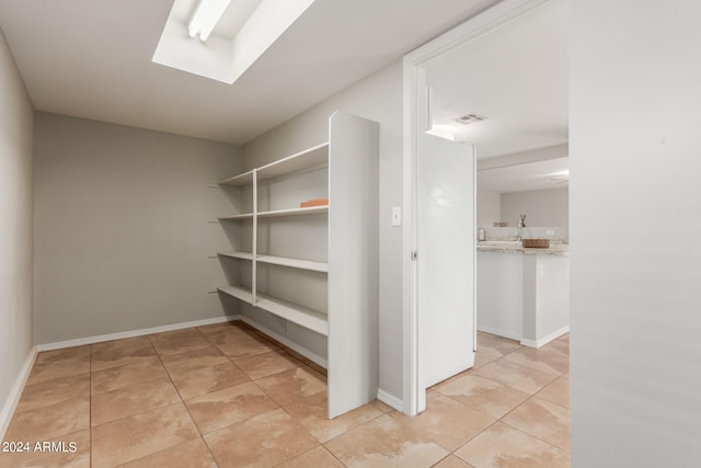 interior space with a skylight and light tile patterned floors