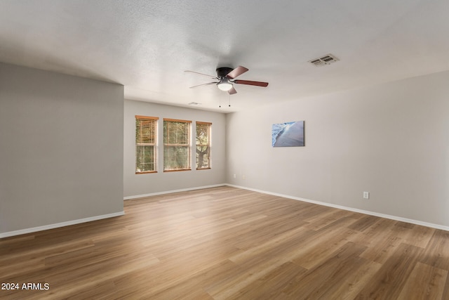 spare room featuring a textured ceiling, ceiling fan, and hardwood / wood-style flooring