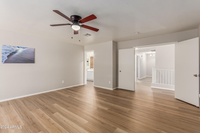 unfurnished bedroom featuring wood-type flooring, connected bathroom, and ceiling fan