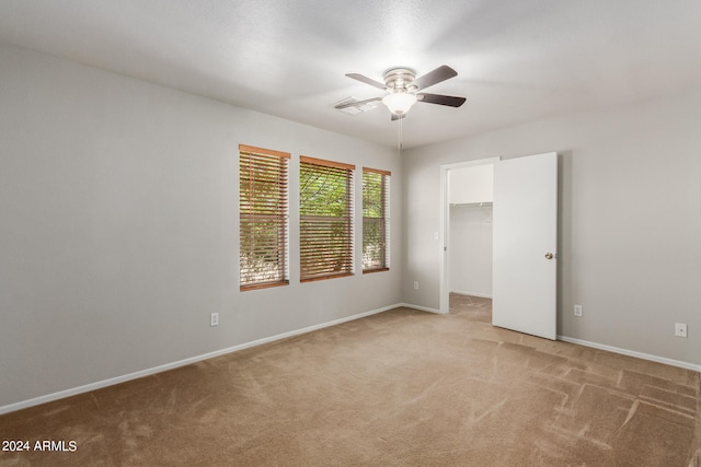 carpeted spare room featuring ceiling fan