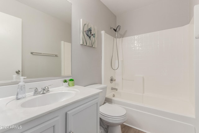 full bathroom featuring hardwood / wood-style floors, shower / tub combination, vanity, and toilet