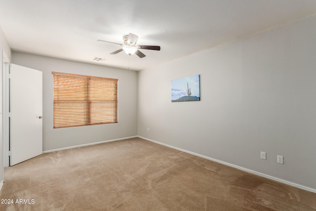 carpeted spare room with ceiling fan