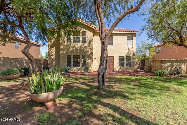 back of house featuring a lawn and a patio