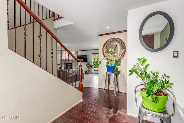 foyer entrance with stairs, baseboards, and wood finished floors