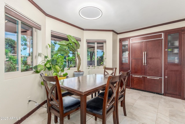 dining space with ornamental molding and baseboards